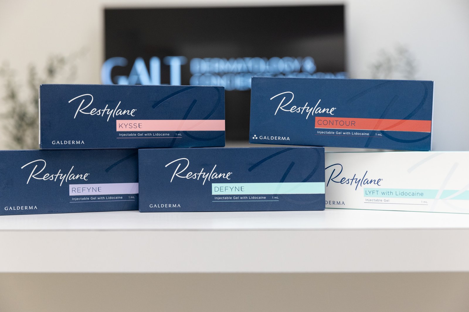 Box of Restylane dermal filler on a clinic counter with syringes and medical tools